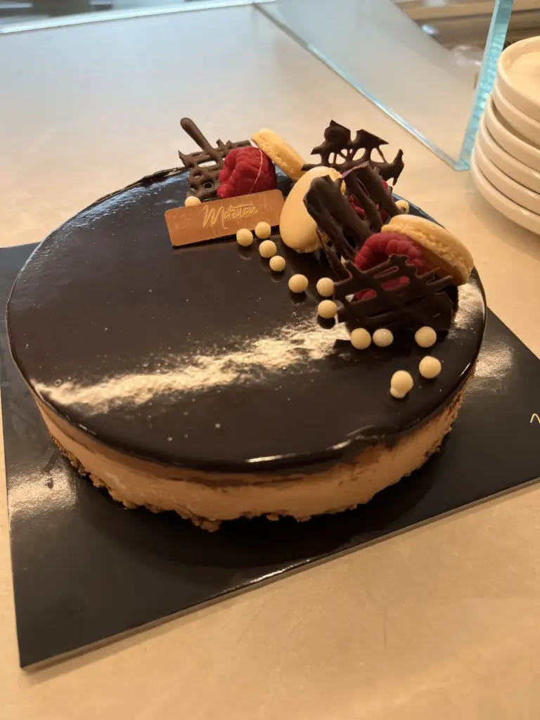 Torta al cioccolato con lamponi e macaron sul banco